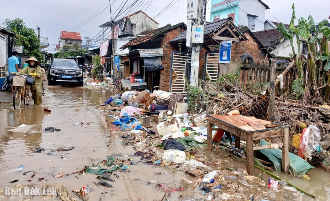 Vägen i byn Thach Tuan 1, Hoa Xuan kommun, efter att översvämningsvattnet dragit sig tillbaka och lämnat efter sig mycket lera och skräp. Foto: Trung Hieu