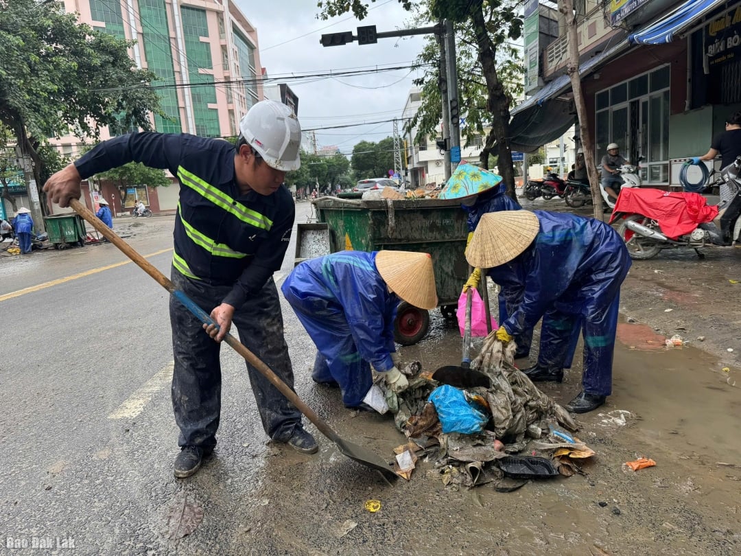 Werknemers van Phu Yen Urban Environment Joint Stock Company gebruiken karren om afval en modder op te halen in de straten van de wijk Tuy Hoa.