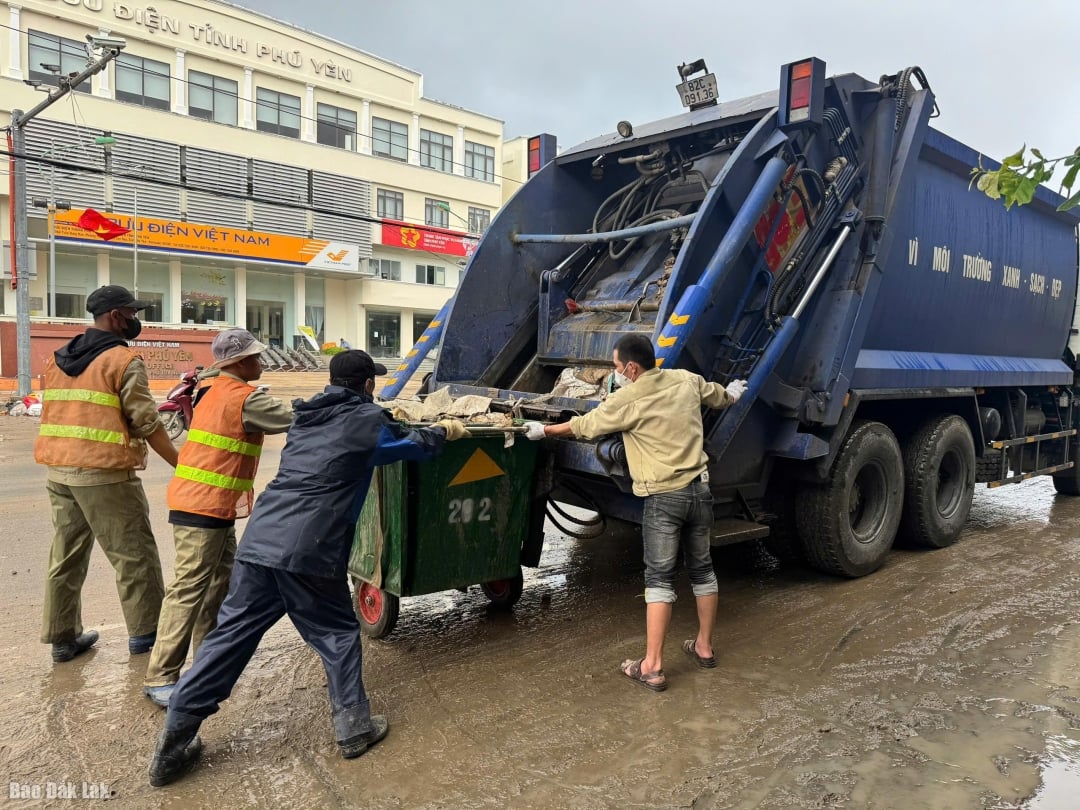Vuilniswagens en werknemers van Kon Tum Environment Joint Stock Company halen afval op in de Tran Hung Dao-straat.