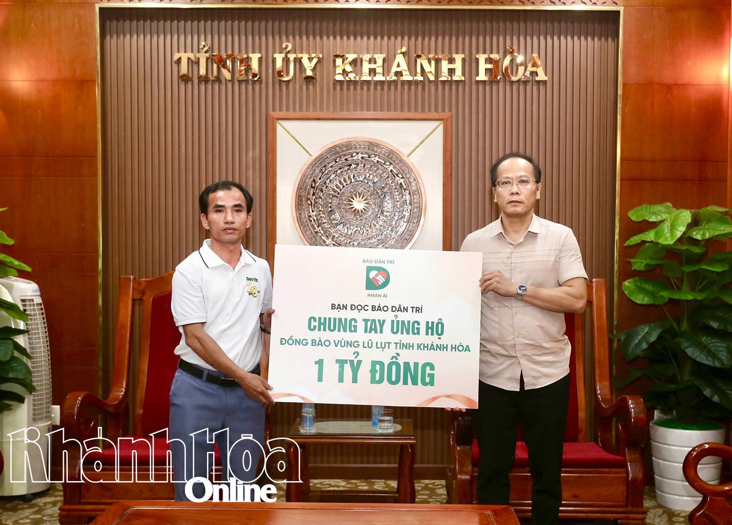 ສະຫາຍ ຫງວຽນ​ແຄ໋ງຮ່ວາ, ຮອງ​ເລຂາ​ຄະນະ​ພັກ​ແຂວງ, ປະທານ​ຄະນະ​ບໍລິຫານ​ງານ​ສູນ​ກາງ​ແນວ​ໂຮມ​ປະ​ເທດ​ຊາດ ຫວຽດນາມ (ຂວາ) ​ໄດ້​ຮັບ​ເງິນ​ສະໜັບສະໜູນ 1 ຕື້​ດົ່ງ​ຈາກ​ຜູ້ຕາງໜ້າ​ໜັງສືພິມ ດ່າ​ນຈີ.