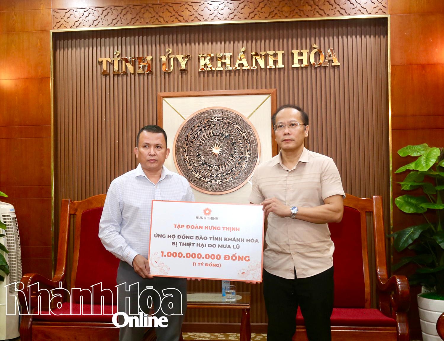 ສະຫາຍ ຫງວຽນ​ແຄ໋ງຮ່ວາ, ຮອງ​ເລຂາ​ຄະນະ​ພັກ​ແຂວງ, ປະທານ​ຄະນະ​ບໍລິຫານ​ງານ​ສູນ​ກາງ​ແນວ​ໂຮມ​ປະ​ເທດ​ຊາດ ຫວຽດນາມ (ຂວາ) ​ໄດ້​ຮັບ​ເງິນ​ຊ່ວຍ​ເຫຼືອ 1 ຕື້​ດົ່ງ​ຈາກ​ວິ​ສາ​ຫະກິດ ຮຸງ​ທິ້ງ.