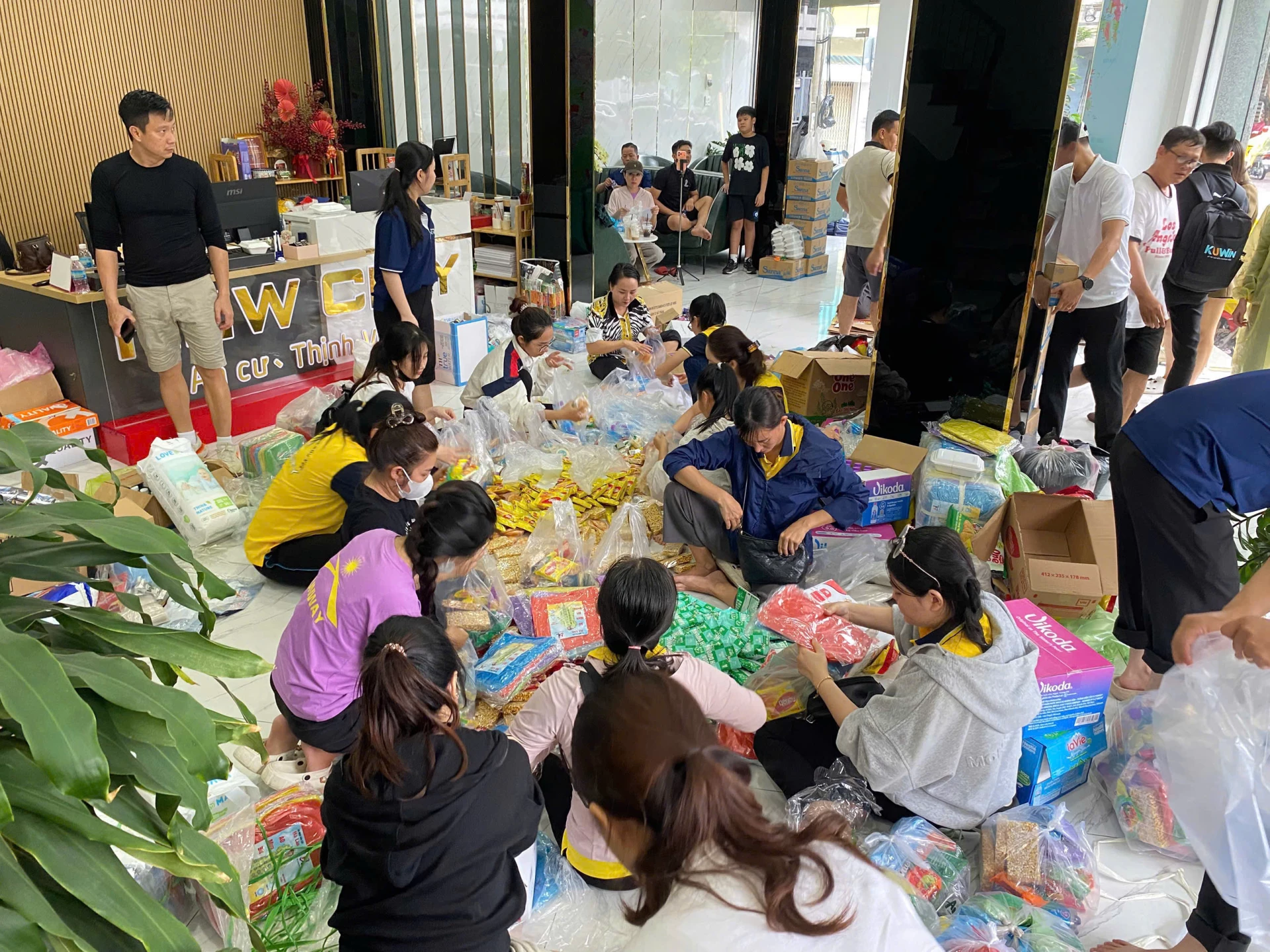 Beratus-ratus pekerja Hartanah Bandar Baru terus membungkus hadiah dan mengangkutnya ke kawasan sukar selepas banjir.