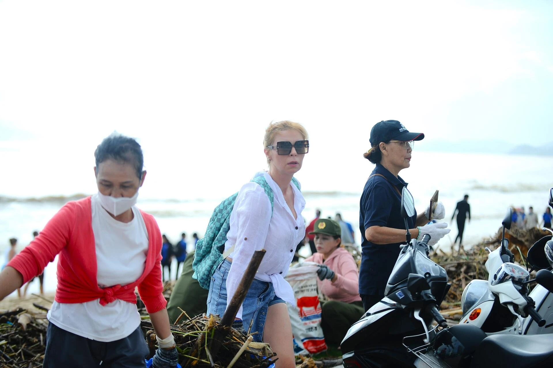 Du khách nước ngoài cùng người dân dọn rác trên biển Nha Trang sau lũ lịch sử