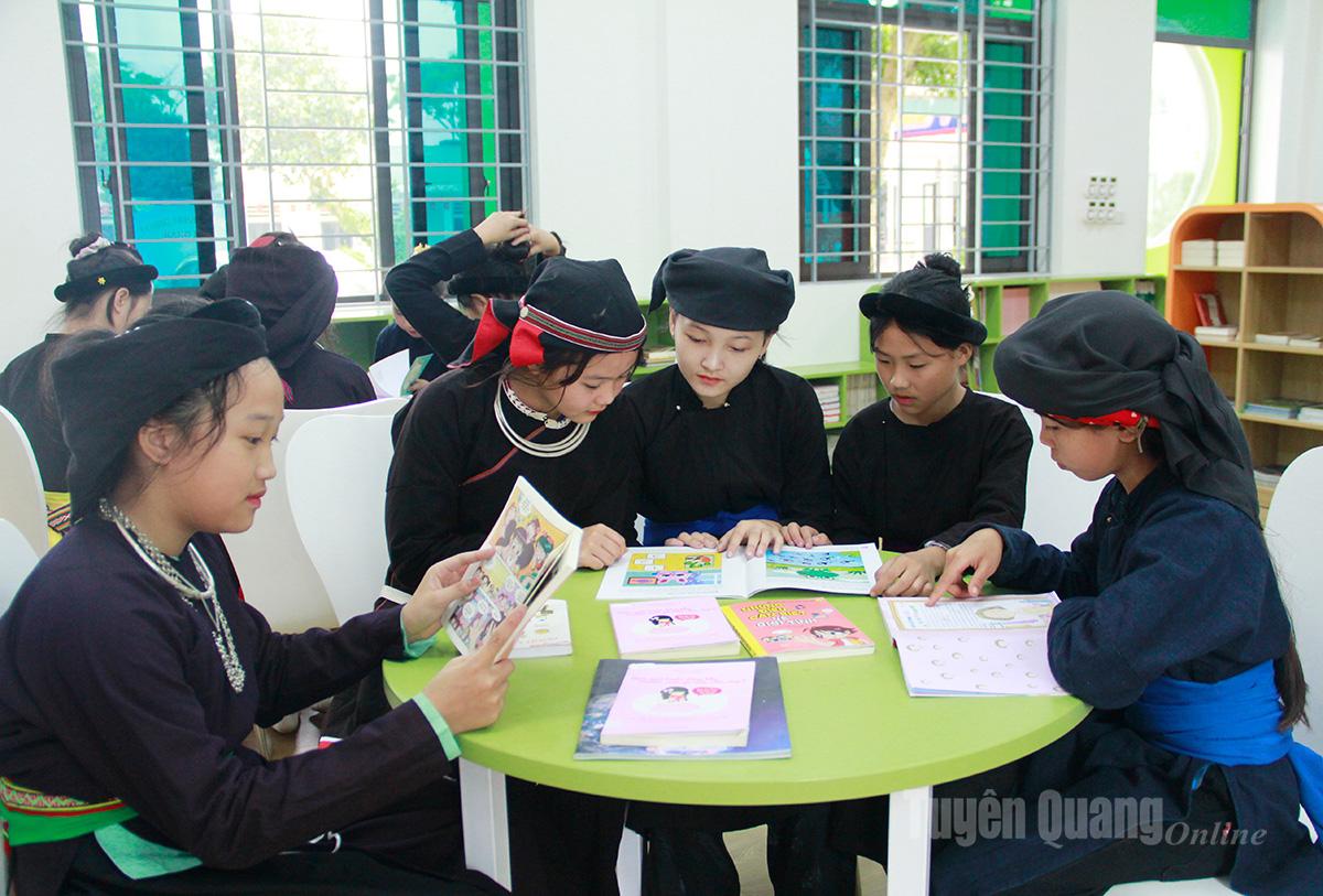 Uczniowie szkoły średniej Bang Lang w gminie Bang Lang czytają książki w bibliotece.