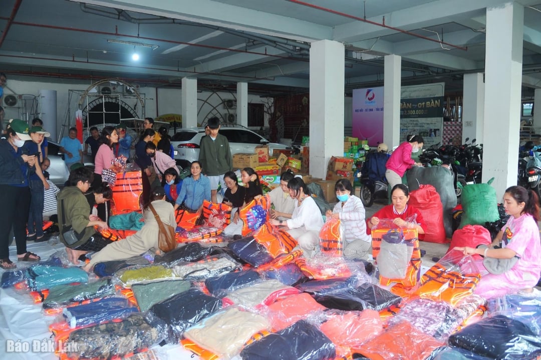 Волонтеры сортируют и упаковывают товары и предметы первой необходимости в подарочные пакеты, чтобы оказать поддержку людям в районах, пострадавших от наводнения.