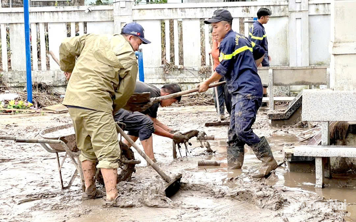 Agentes de policía de la provincia de Dong Nai participan en la limpieza del lodo de las calles de Tuy Hoa. Foto: H.T. 