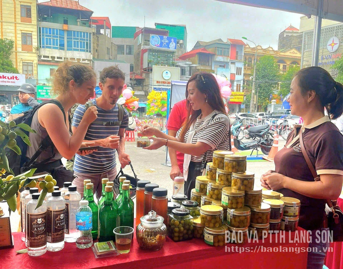 Pelancong asing menikmati produk jem lemon liar Koperasi Ladang Ekologi Mau Son di gerai pameran produk.