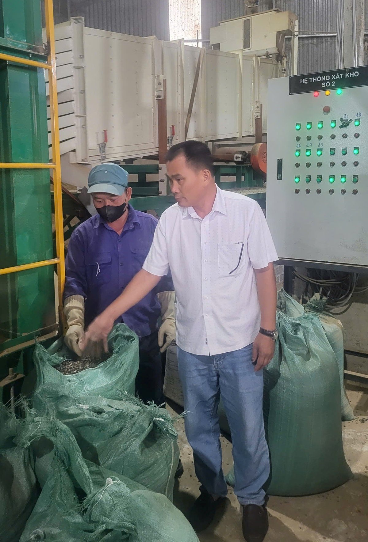 Ông Vương Bá Trung, Phó Giám đốc Công ty TNHH xuất nhập khẩu cà phê Việt Bắc kiểm tra chất lượng cà phê trước khi đóng gói thành phẩm. Ảnh: Hoàng Châu. 