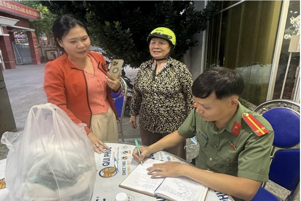 นางเหงียน ถิ เล (ยืนตรงกลาง) และลูกสาวของเธอที่หน่วยรับสิ่งของบรรเทาทุกข์ของตำรวจจังหวัดด่งนาย