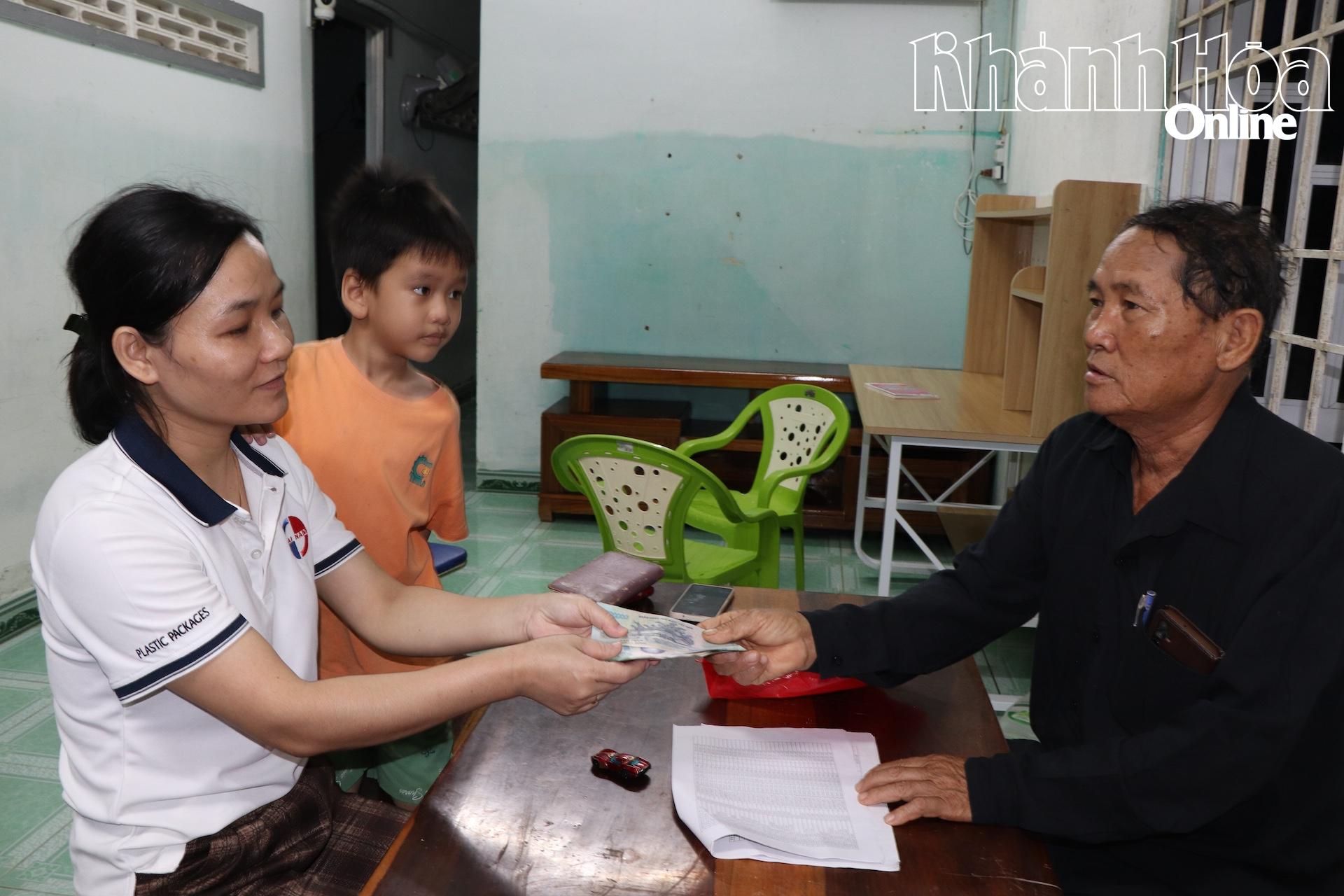 Ketua kampung Trung 1 membayar wang sokongan di rumah penduduk.