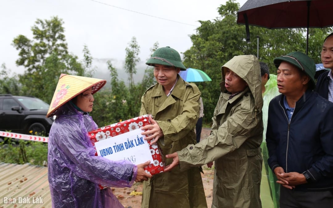 İl Halk Komitesi Başkanı Ta Anh Tuan, heyelan nedeniyle evleri yıkılan hanelere hediyeler sunuyor. Fotoğraf: Thuan Thong