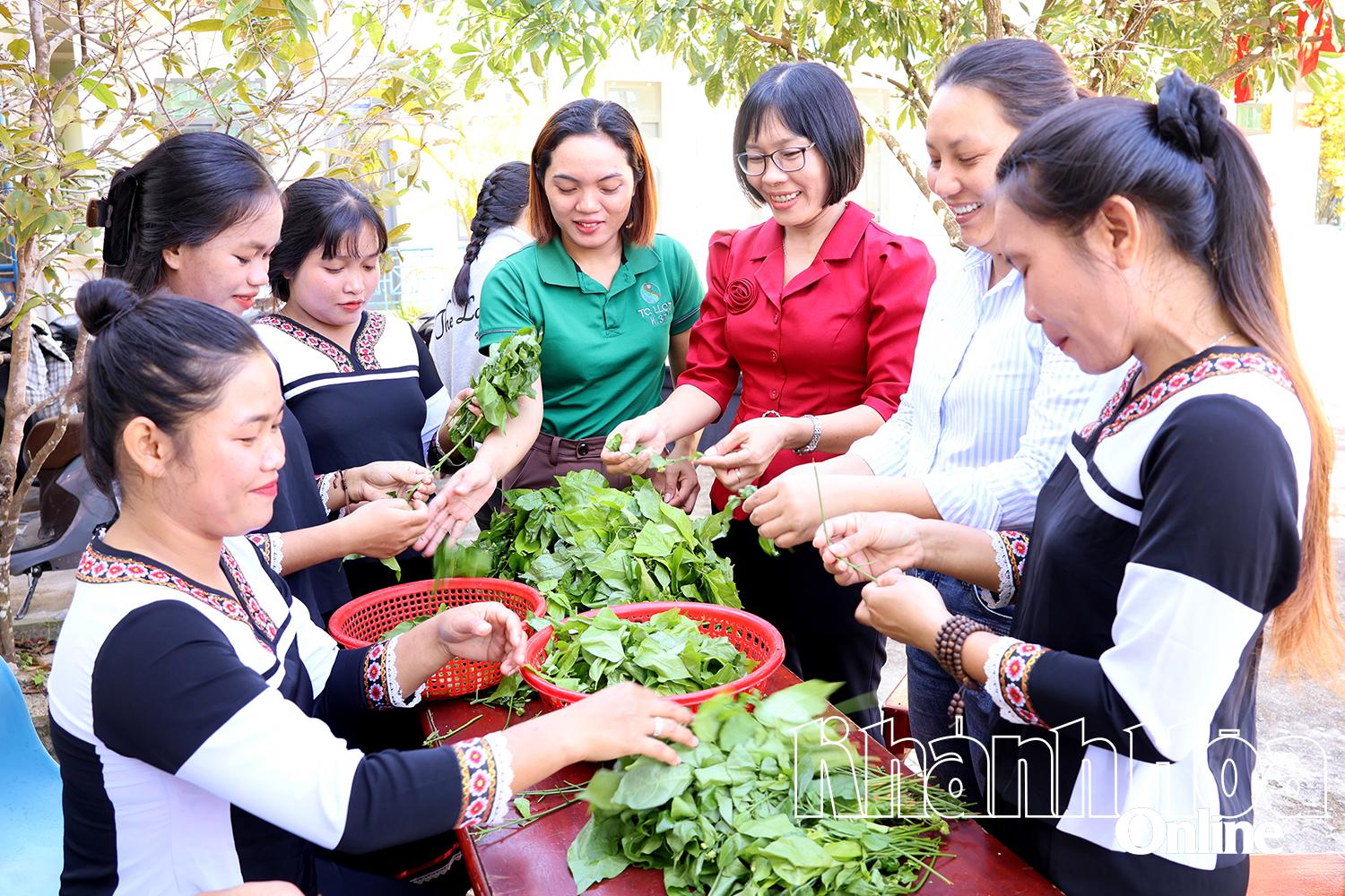 Tjenestemenn og medlemmer av kvinneforeningen i Cam Hiep kommune tilbereder sammen tradisjonelle retter fra Raglai-folket på den etniske kulturfestivalen.