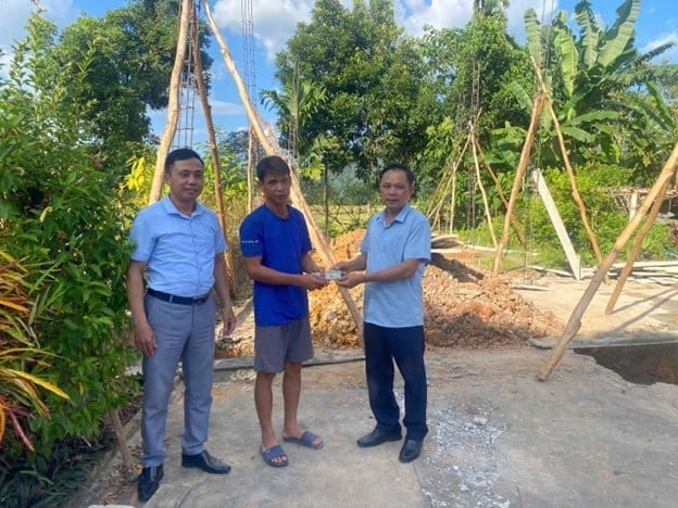 Đại diện chính quyền xã Hưng Khánh trao tiền hỗ trợ xây nhà. Ảnh: Chính quyền địa phương cung cấp.