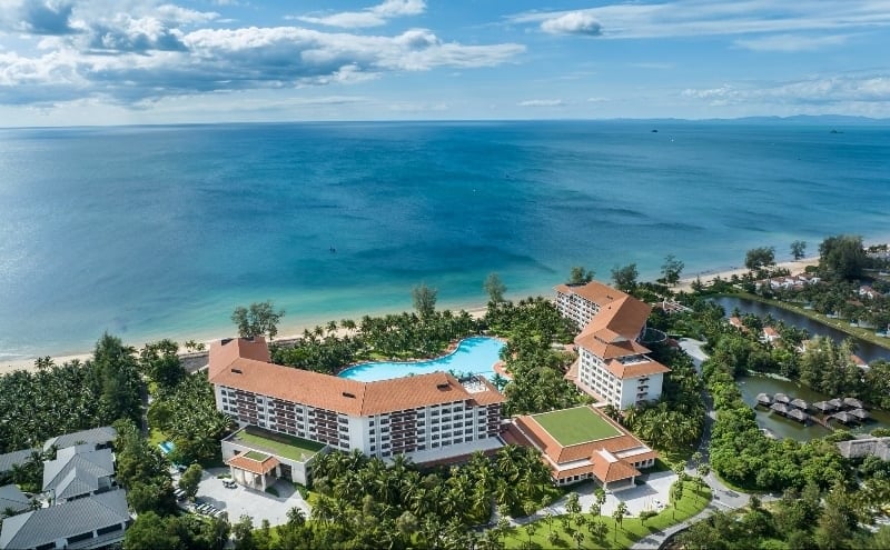 Panoramatický výhled na Vinpearl Resort & Spa Phu Quoc s velkým bazénem a charakteristickou architekturou červené taškové střechy.
