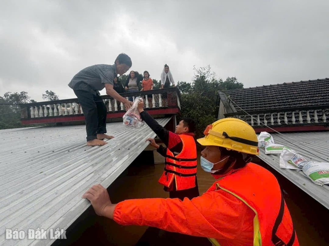 ٹیم Bang Toc اور SOS Ha Tinh کے رضاکار اپنی چھتوں پر سیلاب سے پناہ لینے والے لوگوں کو کھانا فراہم کر رہے ہیں۔ تصویر: T. Quoc