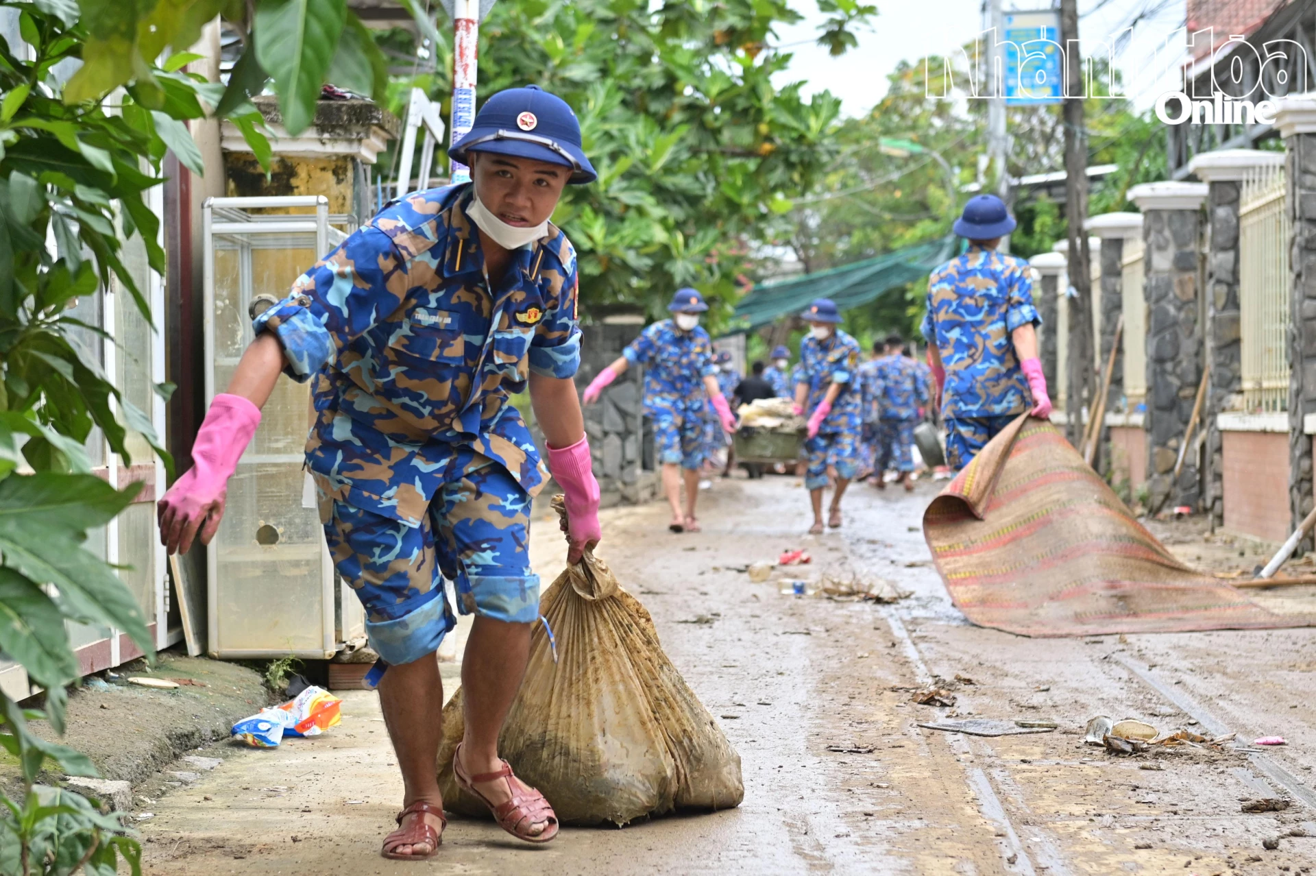 סטודנטים באקדמיה מעבירים אשפה בסמטאות לנקודת איסוף האשפה.