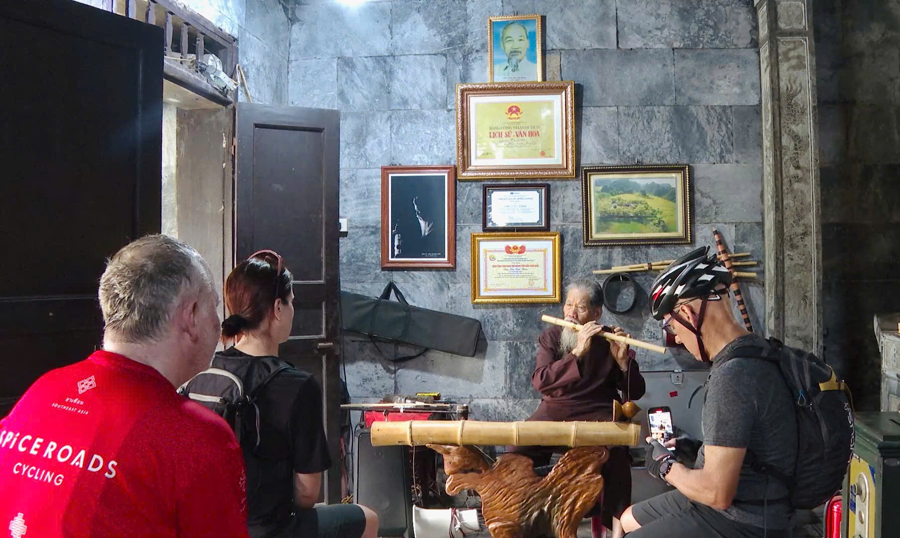 Οι ξένοι τουρίστες ακούν το φλάουτο από μπαμπού που ερμηνεύει ο κ. Chu Van Thim.