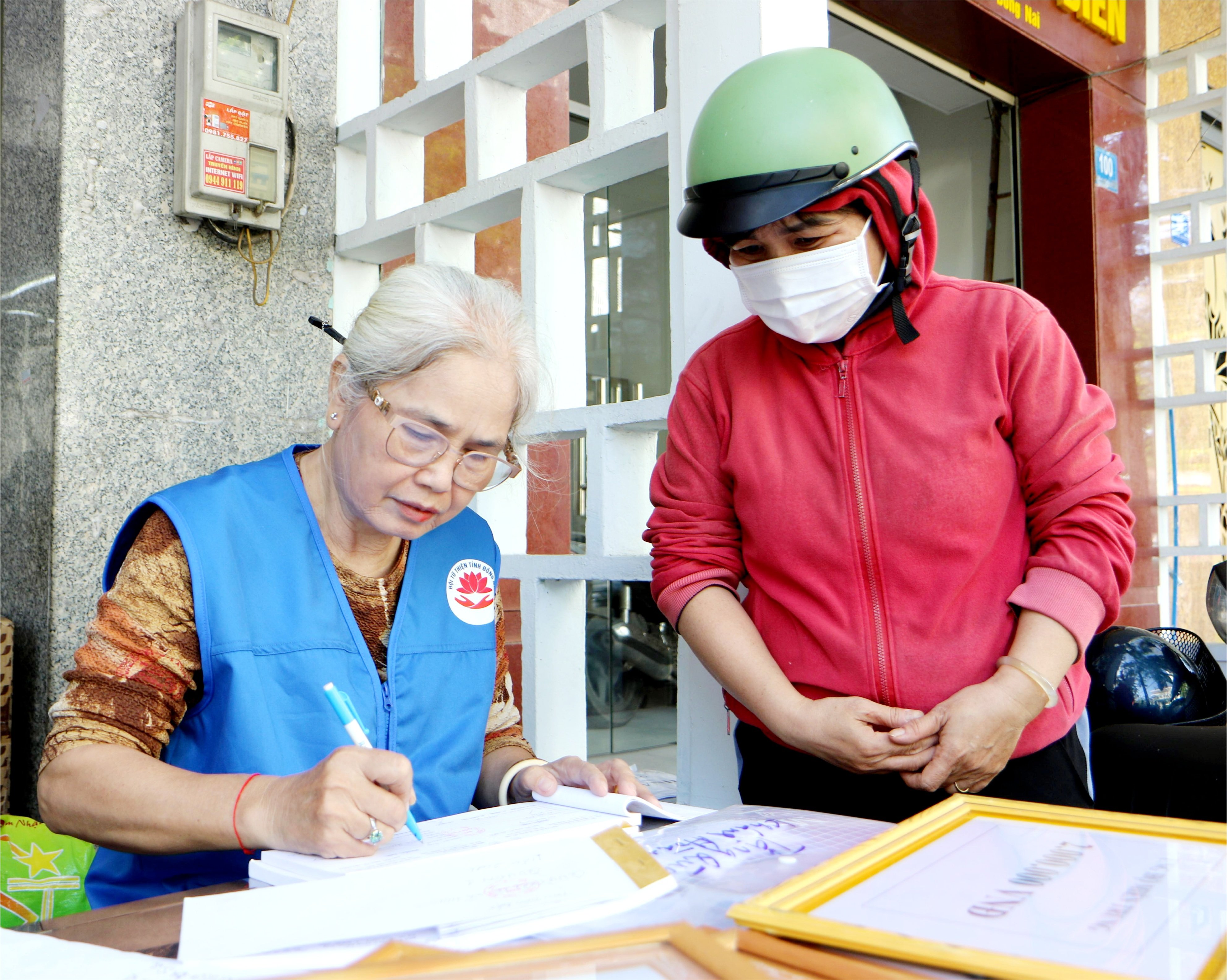 Một người dân giấu tên ủng hộ tiền giúp bà con bị ảnh hưởng bởi thiên tại tại trụ sở Hội Từ thiện tỉnh Đồng Nai. Ảnh: Văn Truyên