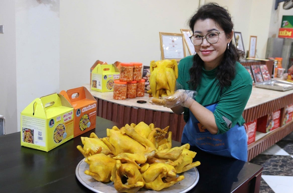 Chị Nguyễn Thị Hồng Xiêm giới thiệu mẻ gà vàng óng vừa hoàn thiện, sản phẩm đang được nhiều du khách tìm mua. Ảnh: Hoàng Nghĩa.