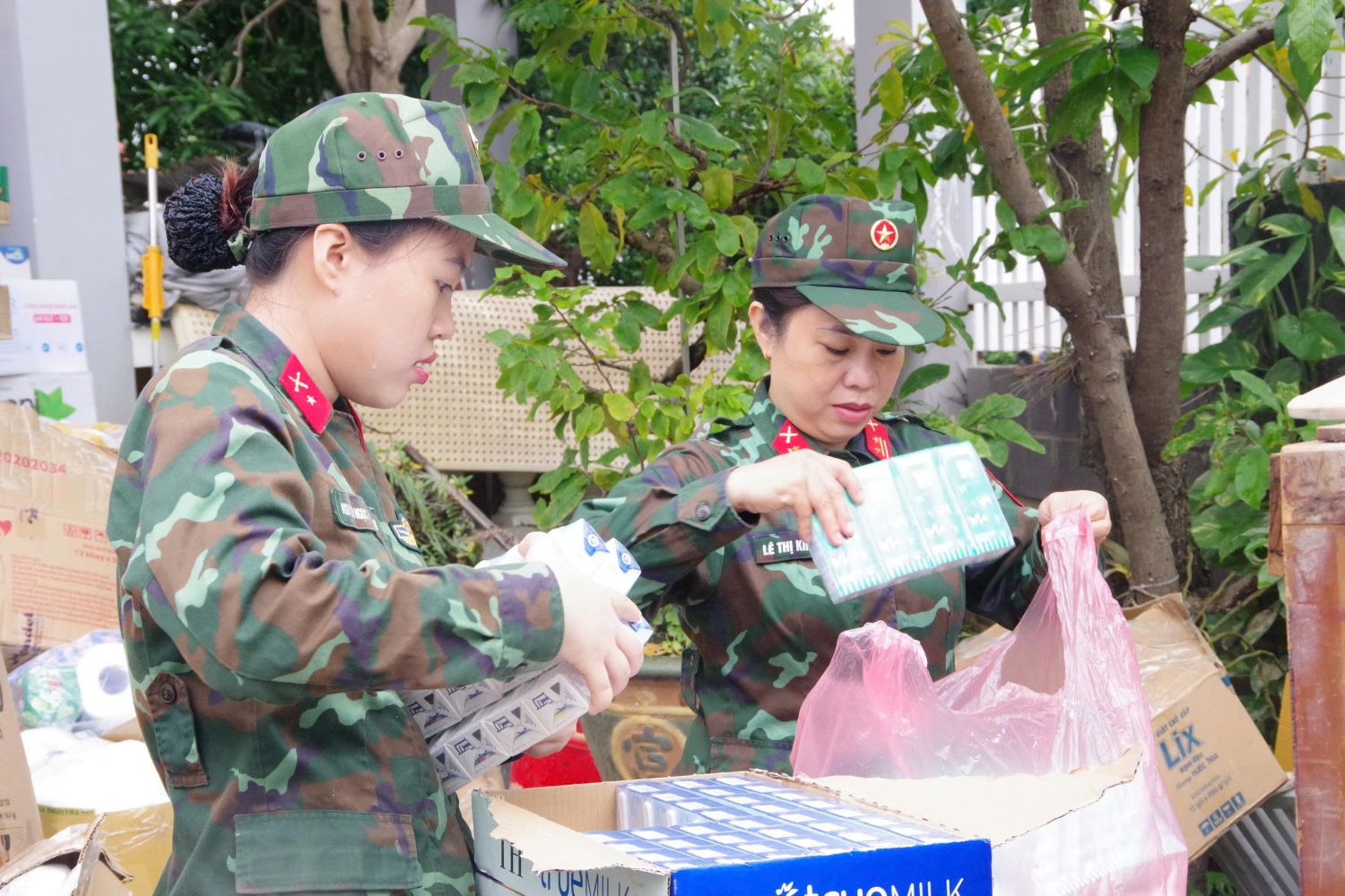 Αξιωματικοί και μέλη γυναικείων ενώσεων της Επαρχιακής Στρατιωτικής Διοίκησης ταξινομούν είδη πρώτης ανάγκης.