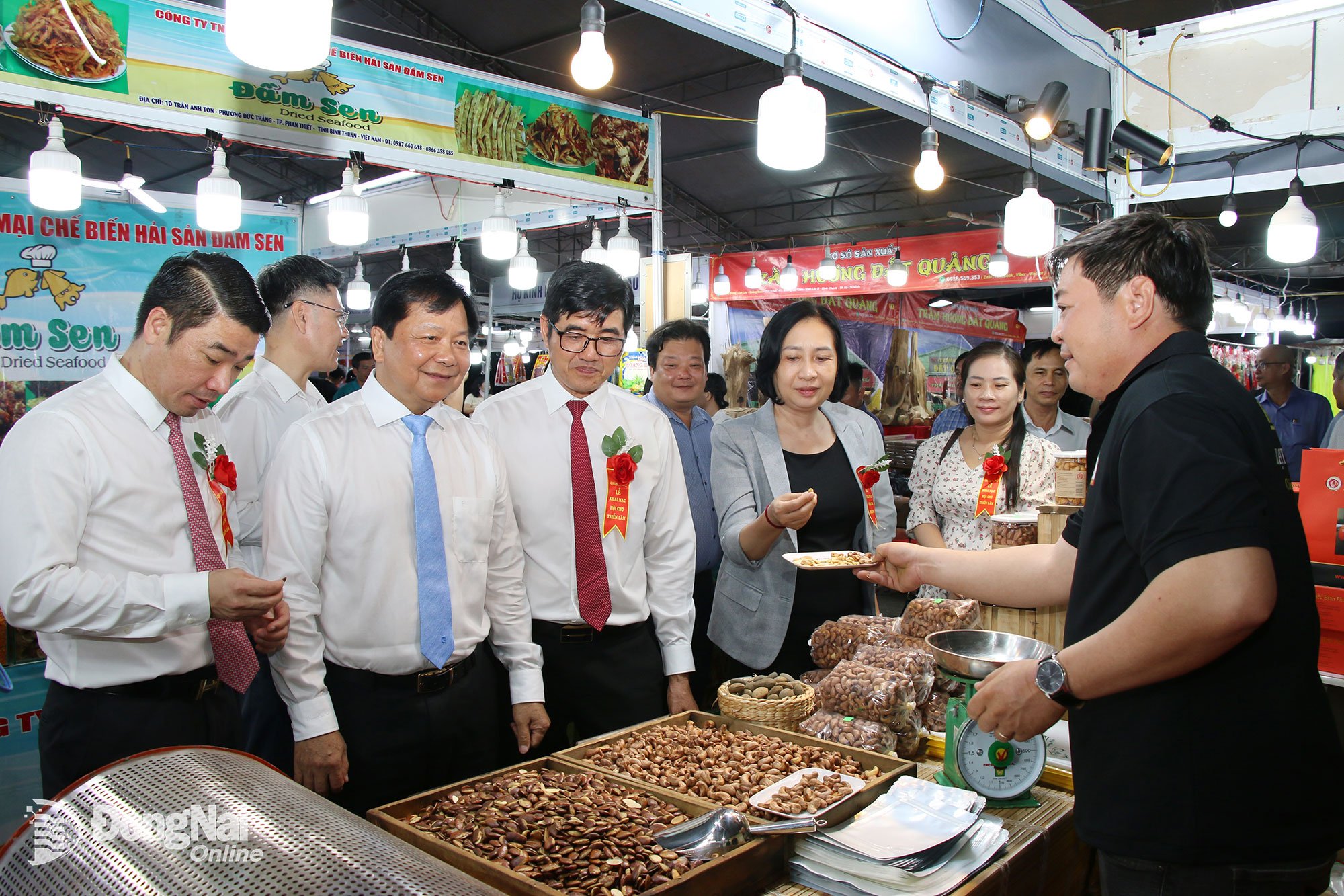 Tran Van Mi (primeira fila, segundo da esquerda para a direita), membro do Comitê Provincial do Partido e vice-presidente do Conselho Popular da Província de Dong Nai, visita um estande na Feira de Produtos Industriais Rurais Típicos da Região Sudeste de 2025, em Dong Nai. Foto: Hai Quan