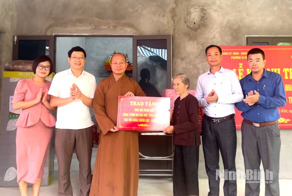 Ledare för partikommittén, folkkommittén och fosterlandsfrontkommittén i Vi Khe Ward överlämnade en symbolisk plakett för att stödja finansieringen av byggandet av det stora solidaritetshuset till Ms. Do Thi Dao, Do Xa Trung Residential Group. Foto: Hoang Tuan