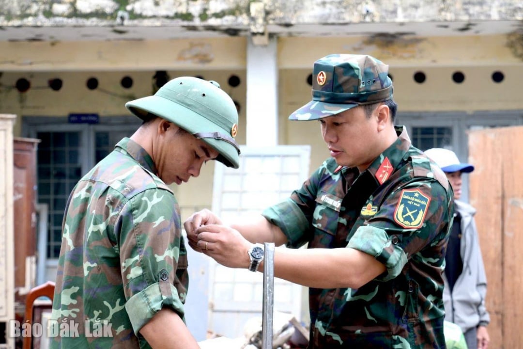 Leftenan Kolonel Vo Trung Hieu, Timbalan Komisar Politik Rejimen 143 (kanan) bertanya tentang keadaan keluarga dan menggalakkan rakan Thien.
