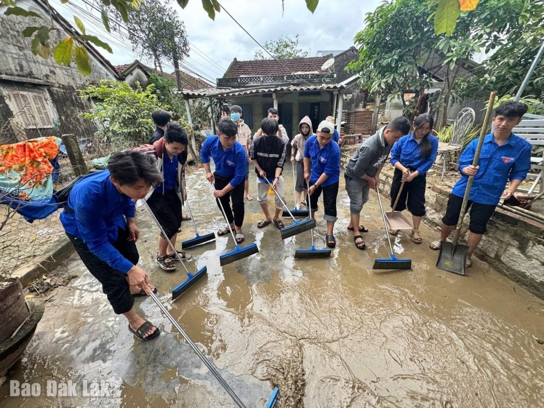Členové mládežnických odborů pomáhají lidem s úklidem domů po povodních.
