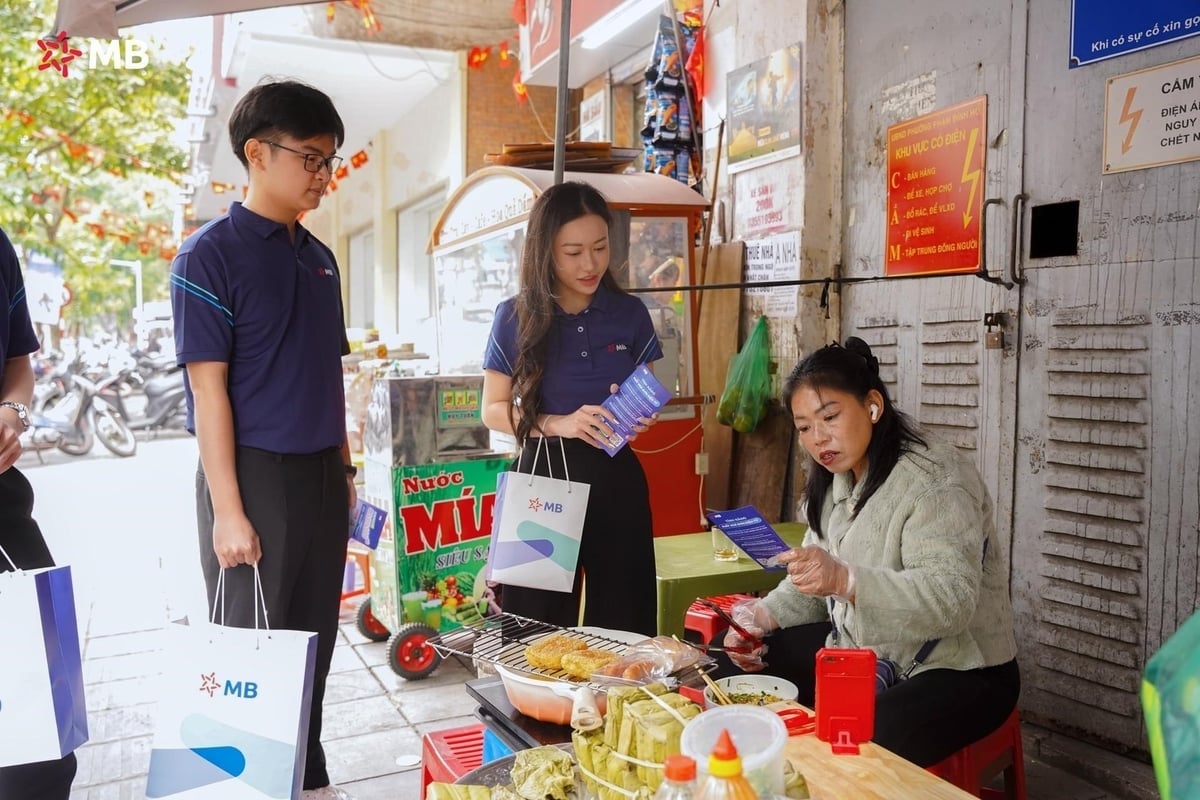 Nhân viên MB hướng dẫn tiểu thương chợ Hôm chuyển đổi số. Ảnh: MB.