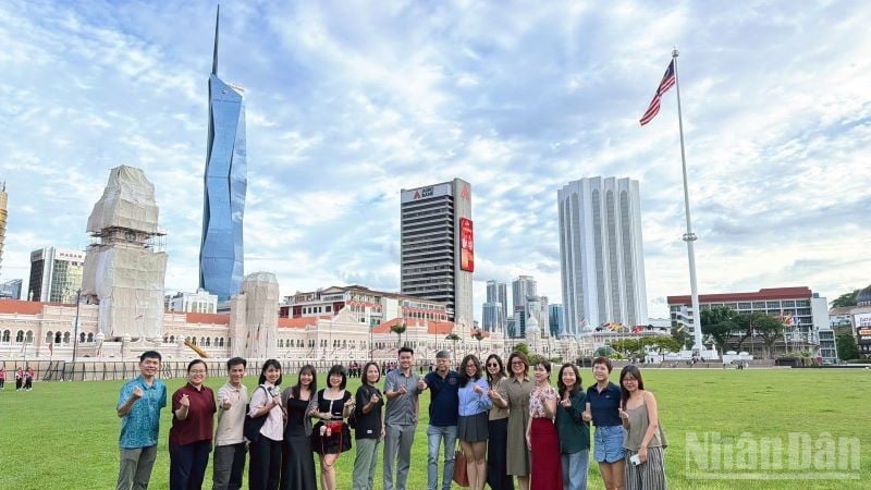 Vietnamesiska turister besöker Merdeka-torget, med det 118 våningar höga Merdeka-tornet, en symbol för Malaysias självständighet.