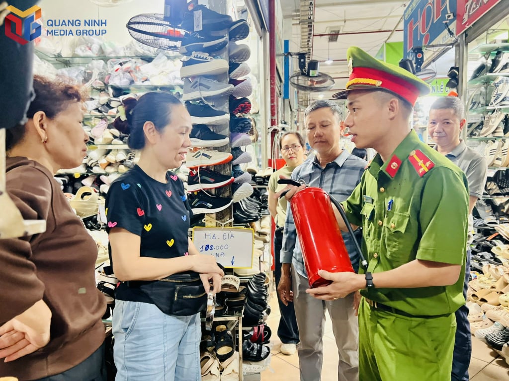 Ms. Pham Thi Hop (second from left) and traders are instructed on how to use fire extinguishers.