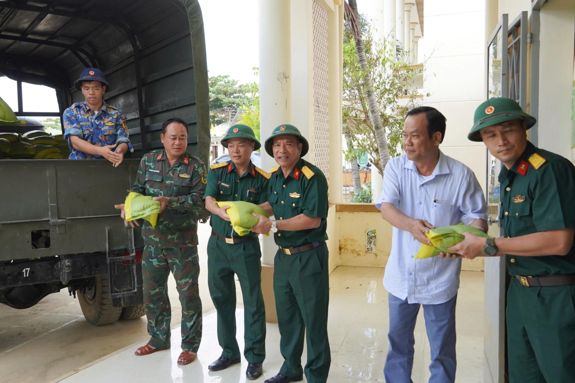 Kepala sekolah memberikan bantuan beras kepada masyarakat Dien Dien.