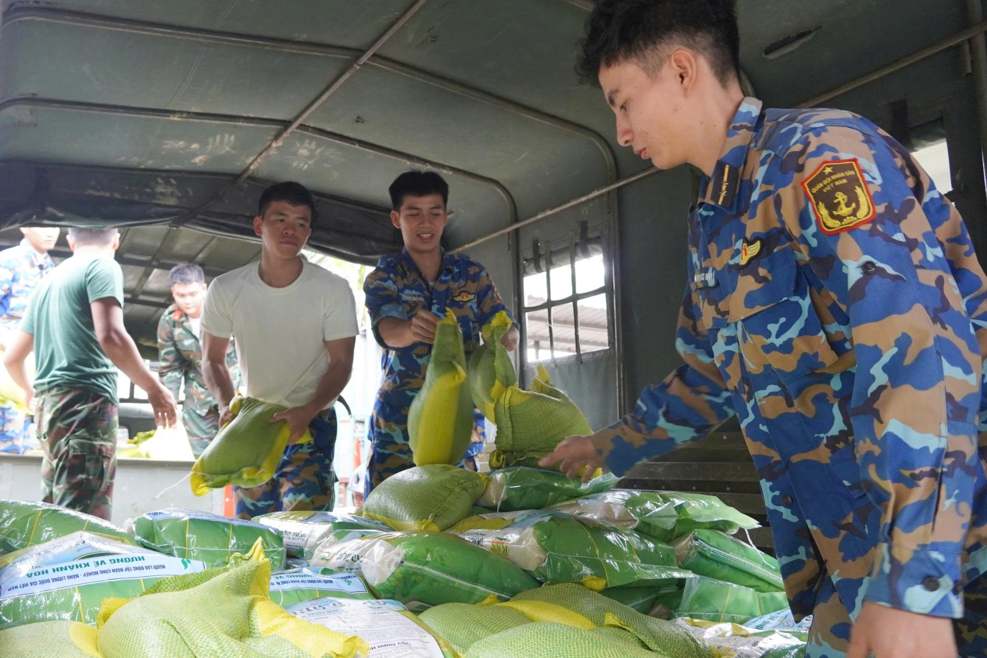Staf sekolah dan tentara mengangkut beras untuk mendukung bangsal Bac Nha Trang.