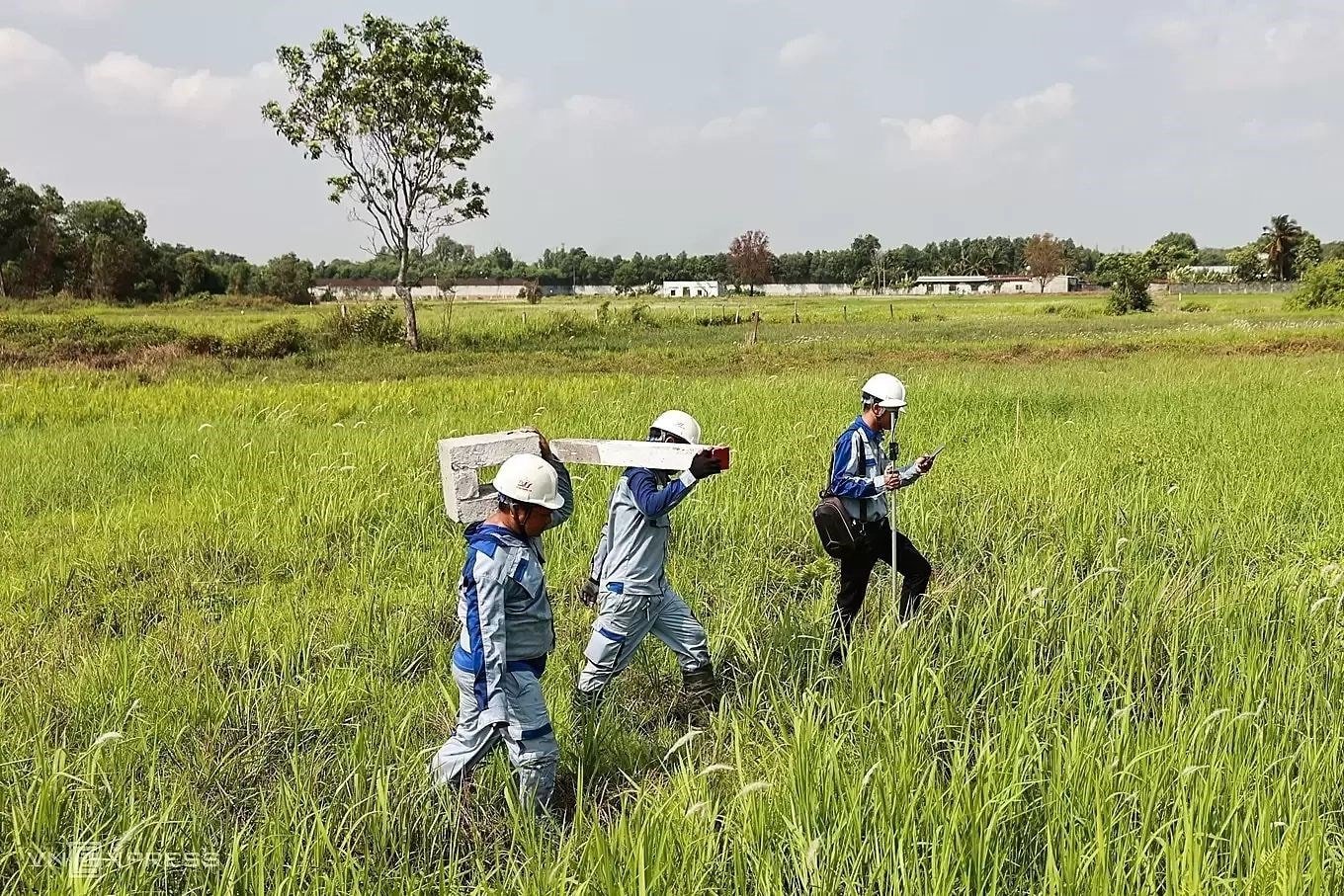 A munkások határcölöpöket állítanak fel, hogy megtisztítsák a területet a Ho Si Minh-város és Moc Báj közötti autópálya számára.