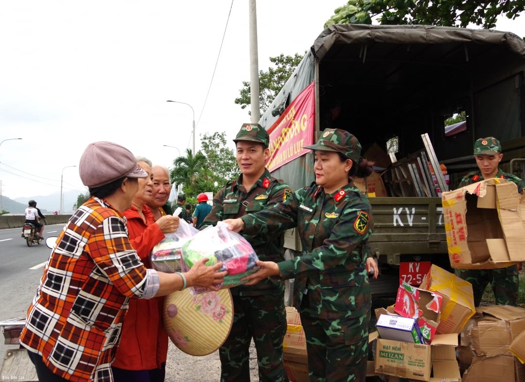 Oficiais do Comando Militar Provincial distribuem pacotes de ajuda às vítimas das enchentes.
