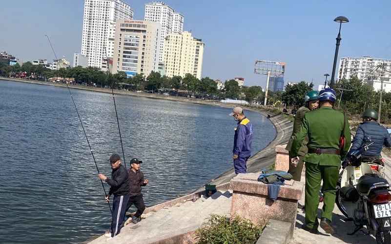 Lực lượng công an phường nhắc nhở người dân không tụ tập câu cá tại hồ Linh Đàm, trưa 26/11