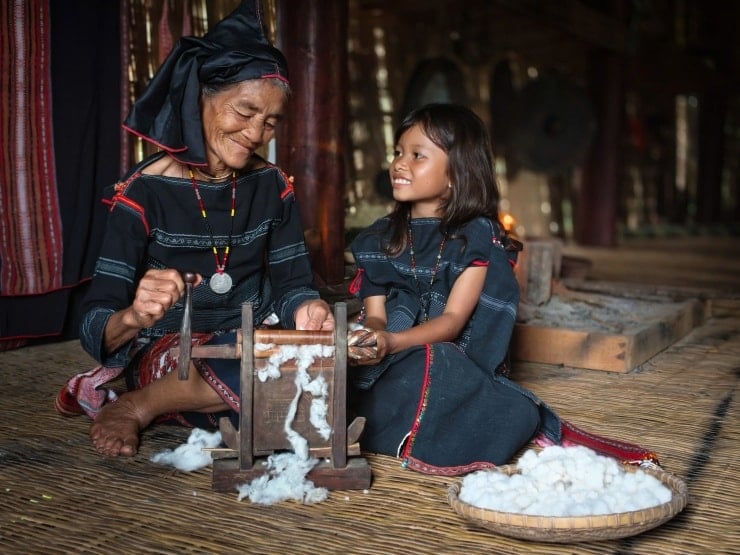একজন দাদী তার নাতনিকে তুলা প্রক্রিয়াজাতকরণ দেখাচ্ছেন। ছবি: এনগো ট্রান হাই আন।