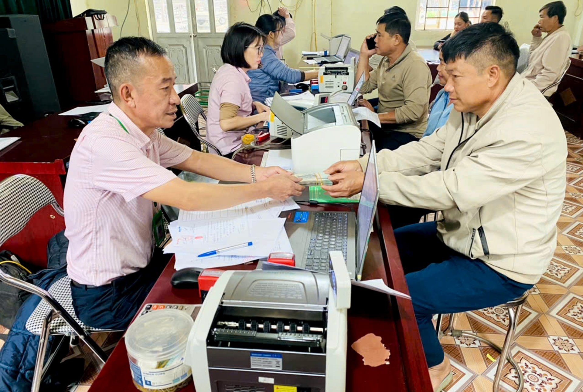 Cán bộ Phòng Giao dịch Ngân hàng CSXH Than Uyên rải nguồn vốn cho các hộ vay xây dựng nhà ở.