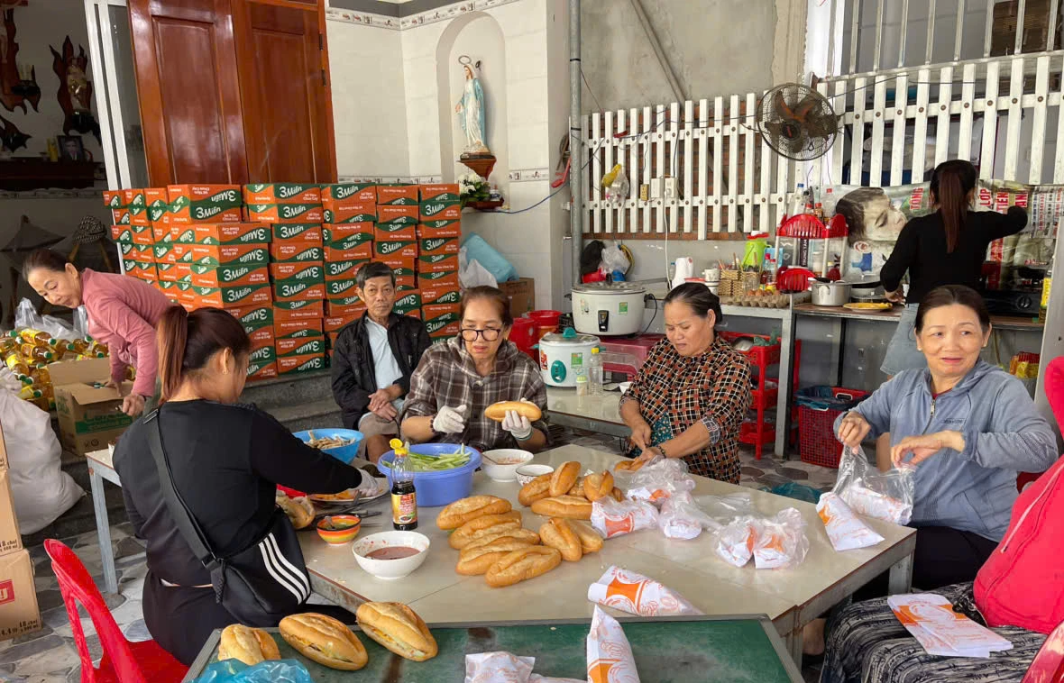 Жінки комуни Кам Лам беруть участь у підготовці їжі для розсилки людям.