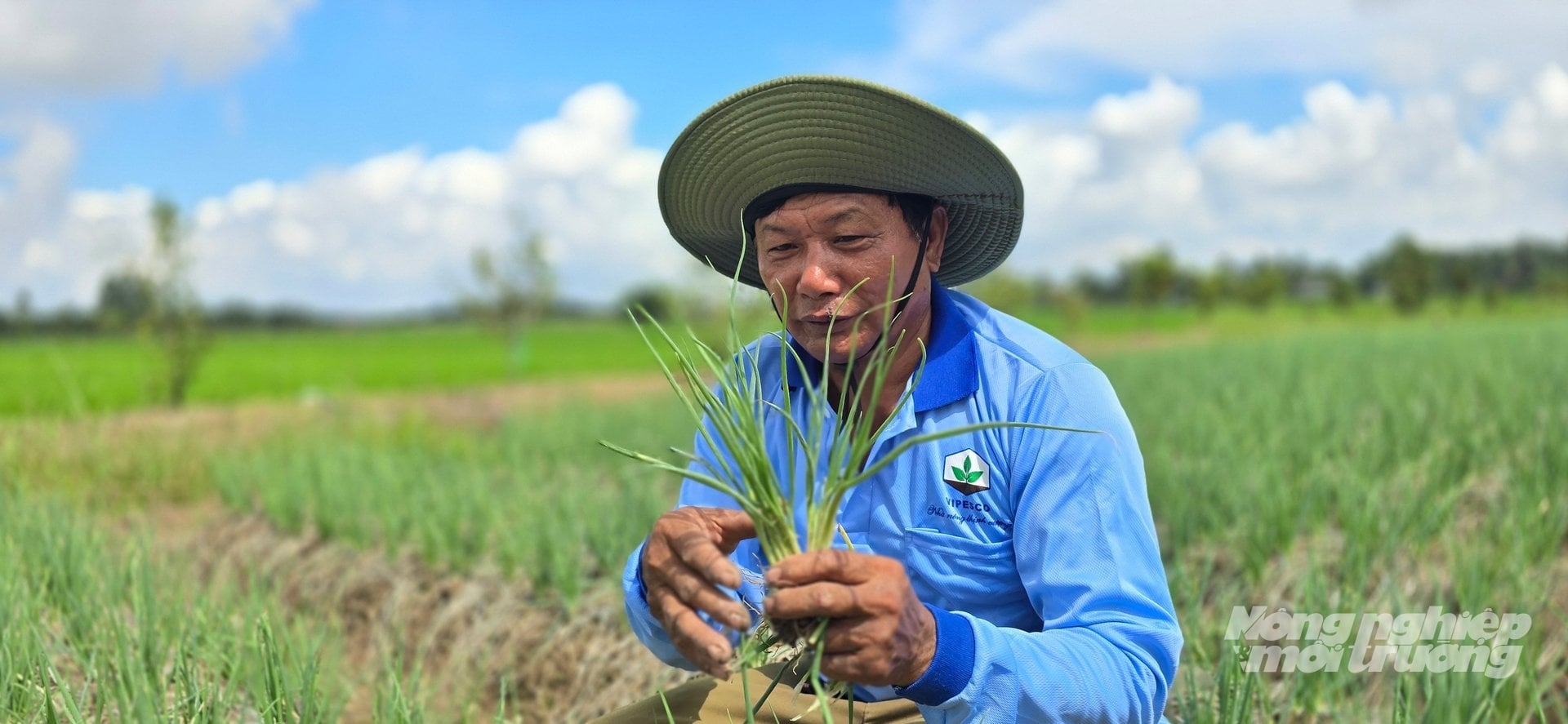 Ông Nguyễn Văn Dí phấn khởi cầm cây hành trên tay, cười vui khoe rằng vụ này ông thu khoảng 50 triệu đồng chỉ sau 50 ngày trồng. Ảnh: Minh Sáng.