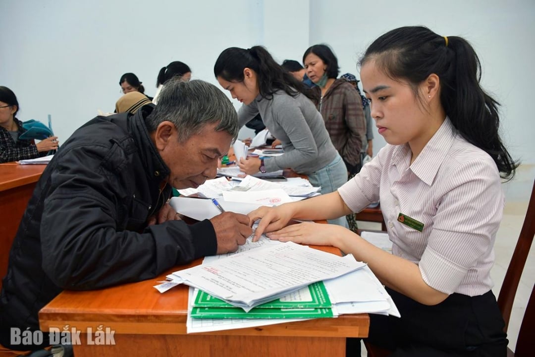 เจ้าหน้าที่สำนักงานธุรกรรมธนาคารนโยบายสังคมฟูเยนให้คำแนะนำประชาชนในการกรอกใบสมัครสินเชื่อ