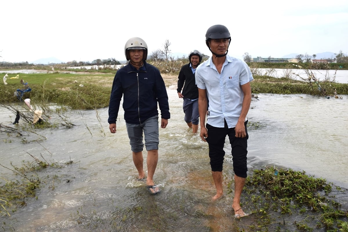 तुई फुओक बाक कम्यून के आर्थिक विभाग के अधिकारियों ने हाल ही में आई बाढ़ के बाद तलछट की जाँच के लिए स्थानीय अधिकारियों के साथ मिलकर पानी में उतरकर काम किया। फोटो: वी.डी.टी. Cán bộ Phòng Kinh tế xã Tuy Phước Bắc phối hợp với địa phương lội nước đi kiểm tra nạn sa bồi sau lũ dữ vừa qua. Ảnh: V.Đ.T.