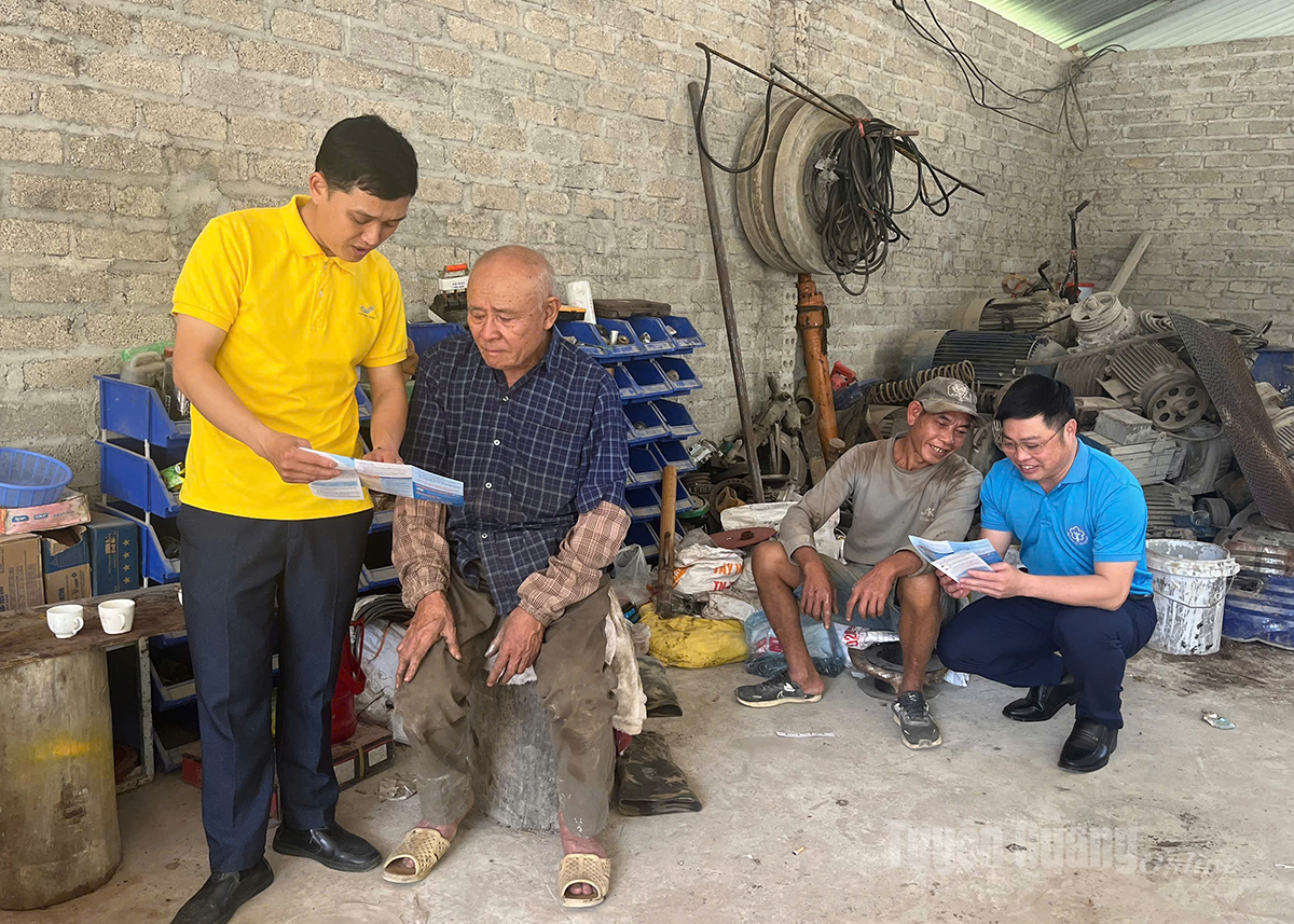 Cán bộ BHXH cơ sở Quản Bạ phối hợp với nhân viên Bưu điện khu vực tuyên truyền chính sách BHXH cho người lao động.