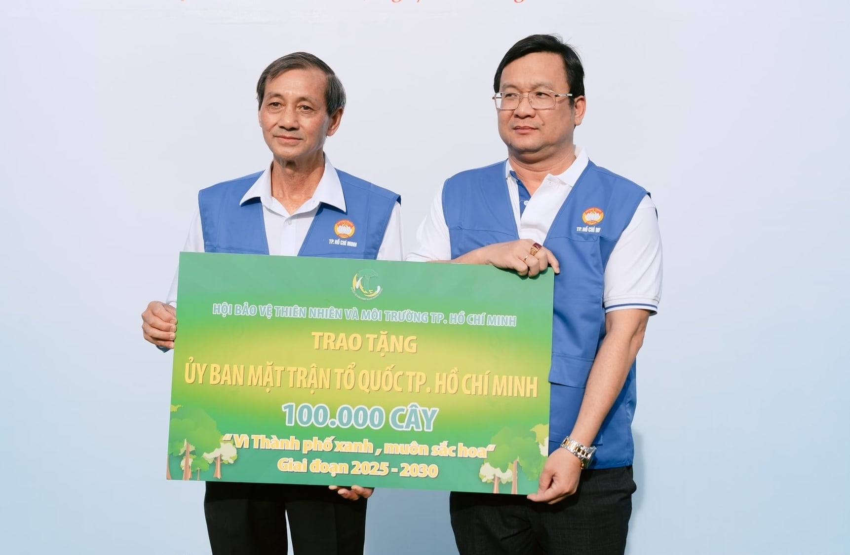 Ông Đặng Văn Khoa, Chủ tịch Hội Bảo vệ Thiên nhiên và Môi trường TP.HCM, trao bảng tượng trưng hỗ trợ 100.000 cây xanh cho phong trào. Ảnh: MTTQ.