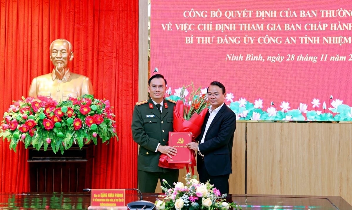 Bí thư Tỉnh ủy Đặng Xuân Phong trao quyết định và tặng hoa chúc mừng Thượng tá Cù Quốc Thắng. Ảnh: Công an tỉnh Ninh Bình. 
