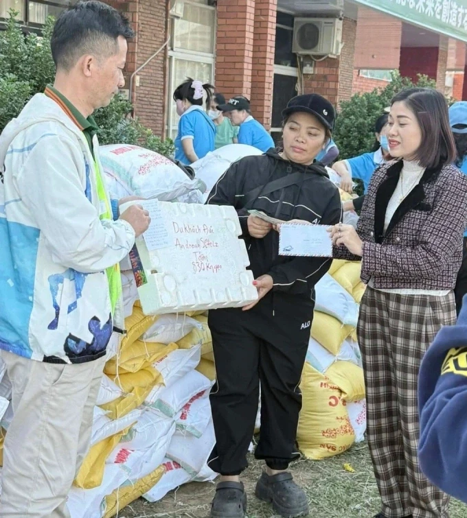 Thanh Hai asszony (jobb szélen) 830 kg rizst ad át német vendégektől a segélycsapatnak. Fotó: NVCC