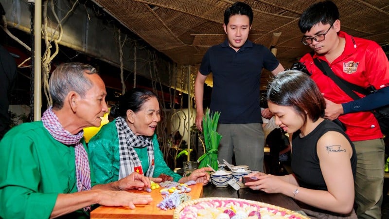 Håndverkerparet Truong Thi Chieu guider turister gjennom opplevelsen av å lage tradisjonelle kaker.