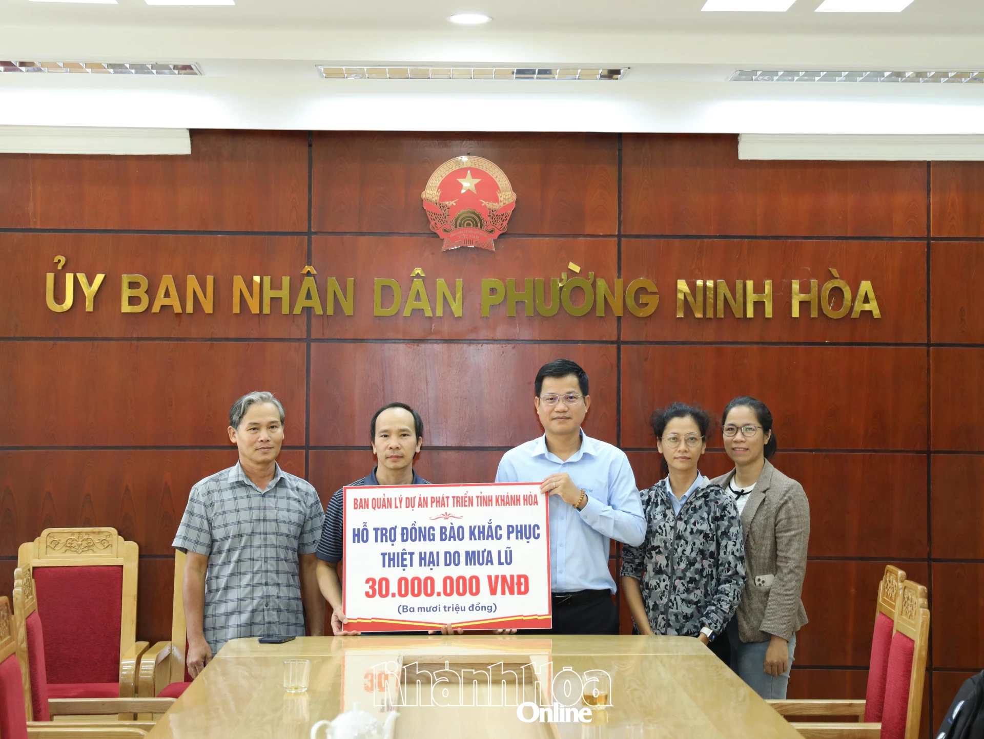 省開発プロジェクト管理委員会のリーダーたちは、洪水による被害を克服するためにニンホア村の人々を支援する象徴的なボードを贈呈した。