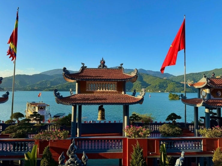 Turister reser med båt för att besöka Thac Bo-templet.