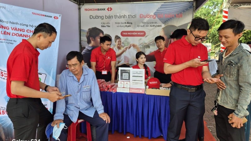 មនុស្សមកស្តង់ធនាគារដើម្បីចូលរួមក្នុងទីផ្សារគ្មានសាច់ប្រាក់ដើម្បីបើកគណនីទូទាត់។